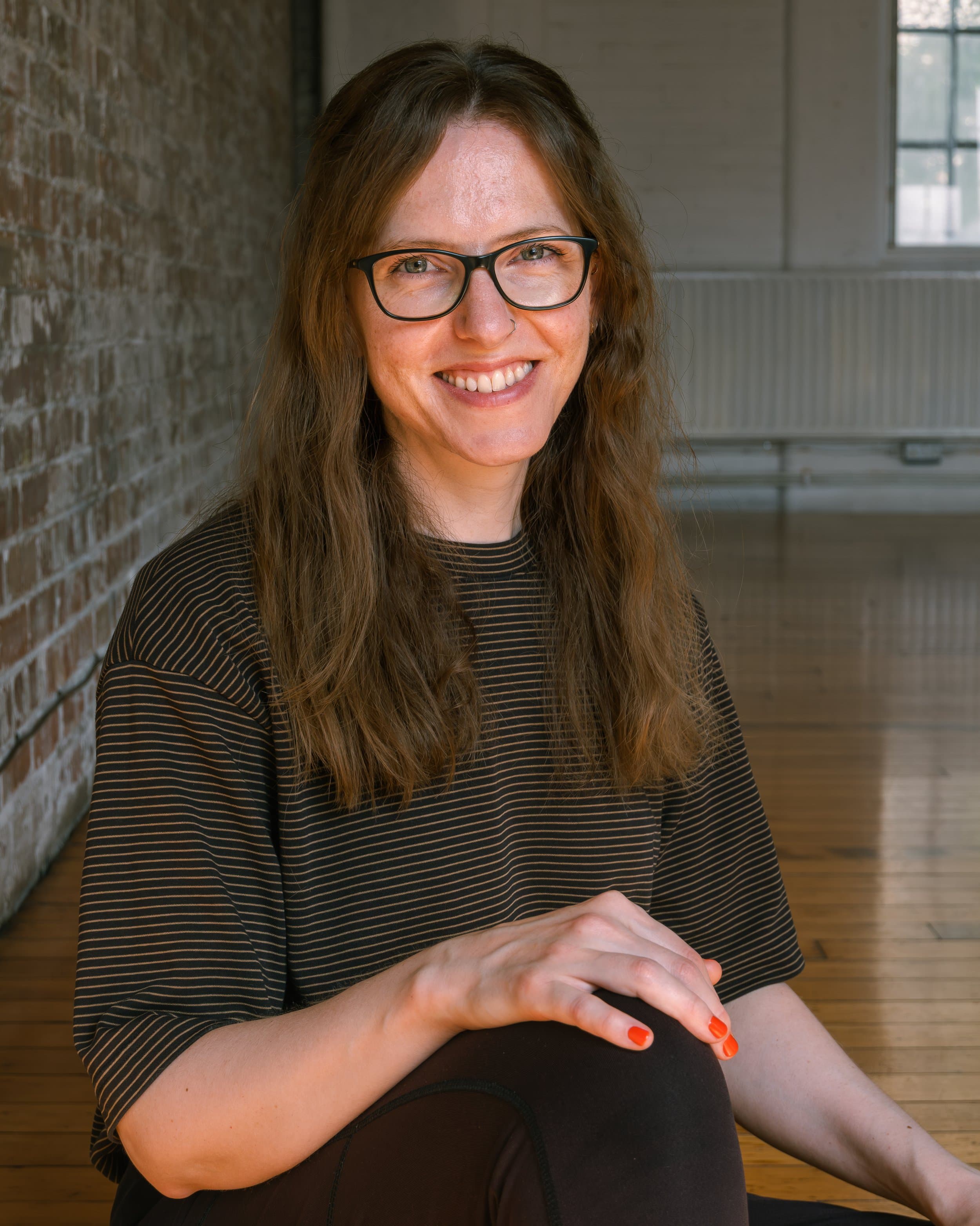 Ellen Leishman, Pilates teacher, sitting cross-legged on a mat